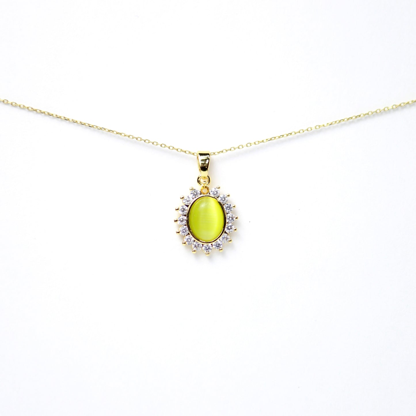 Dije gema ovalada en tono amarillo limón con efecto “ojo de gato” rodeada de Diamantes