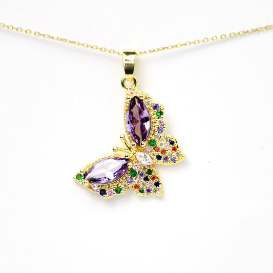 Dije mariposa, adornado con un despliegue de cristales multicolor, realzados por dos piedras amatista en corte marquise, Oro laminado
