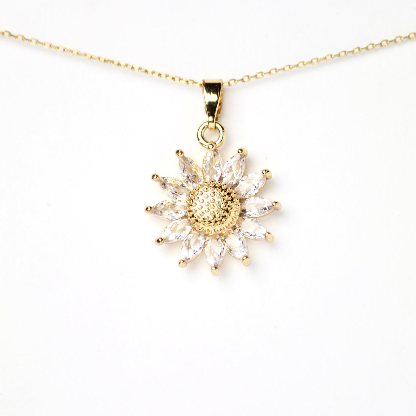 Dije de Girasol con petalos alargados de Zirconias en corte Marquis y circulo central con textura, Oro laminado