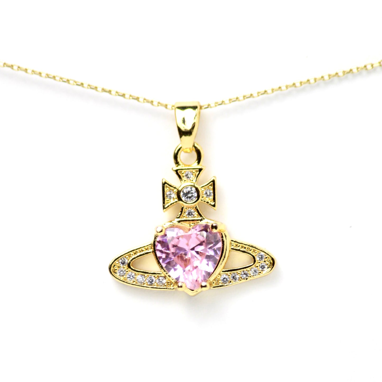 Dije diseño llamativo y reconocible, inspirado en estilo barroco-pop, con un corazón rosa, zirconias brillantes y una estructura tipo símbolo astral o real. Oro laminado